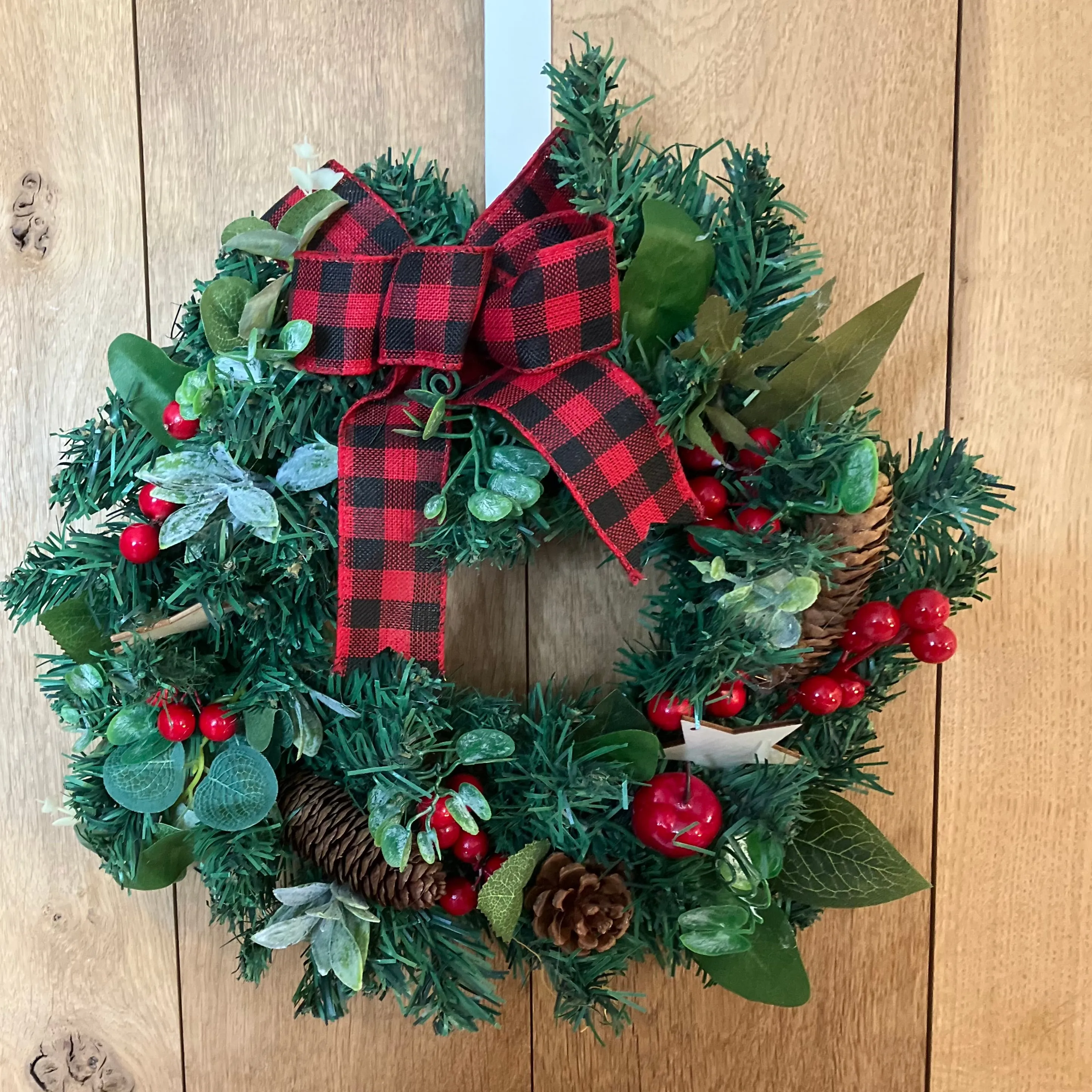 A 33cm pine Christmas wreath with artificial foliage, cones & berries